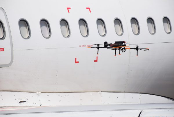An autonomous Donecle drone flies around the fuselage to take pictures for inspection and maintenance operation of aircraft.